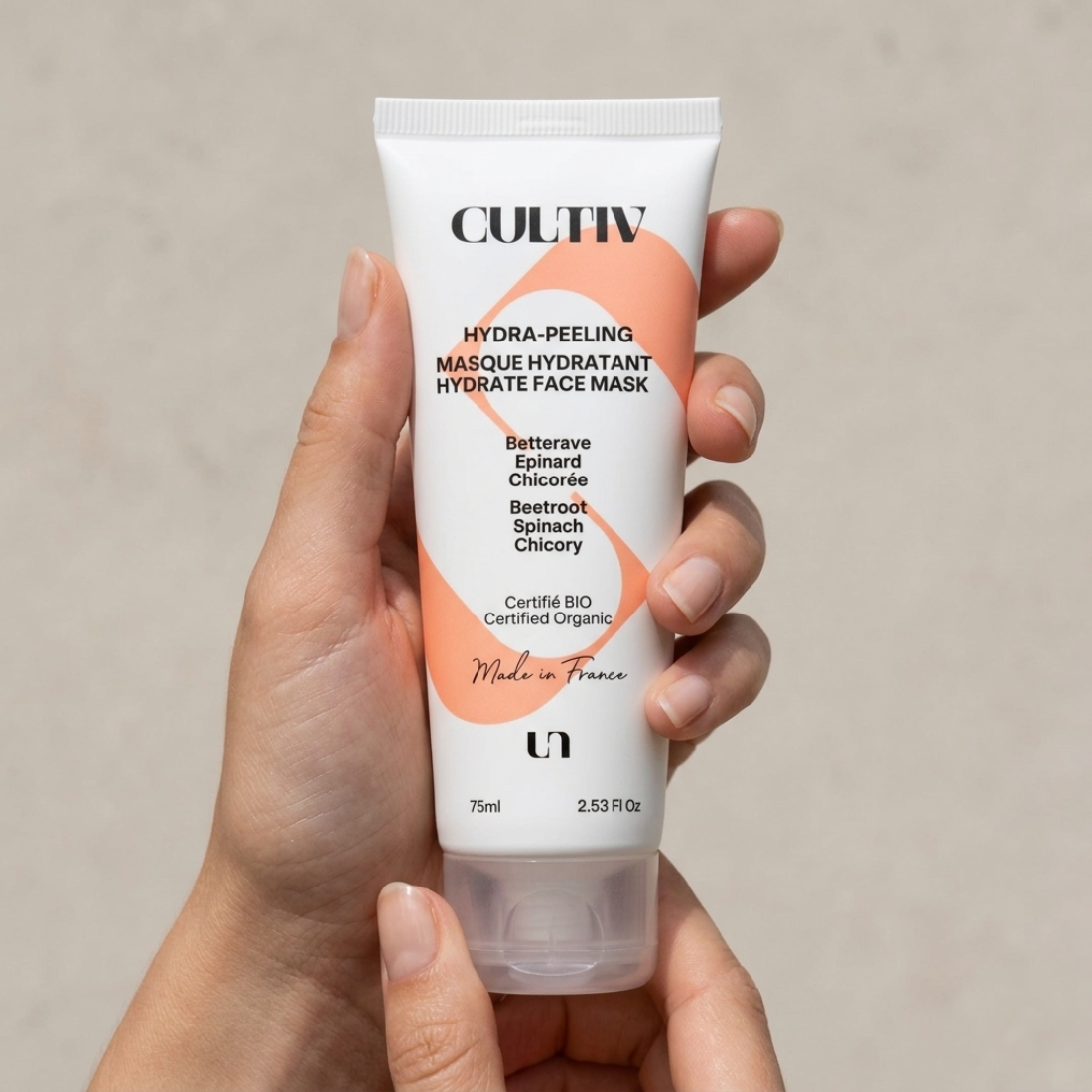 Hand holding a Cultiv Hydra-Peeling face mask tube against a neutral background