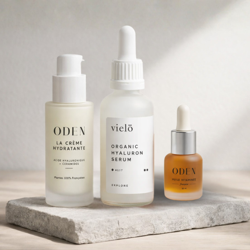 Three skincare bottles from Oden and vielo on a stone surface with a neutral background