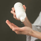 Person holding a Vielö Organic face toner bottle over an open palm with a dark background